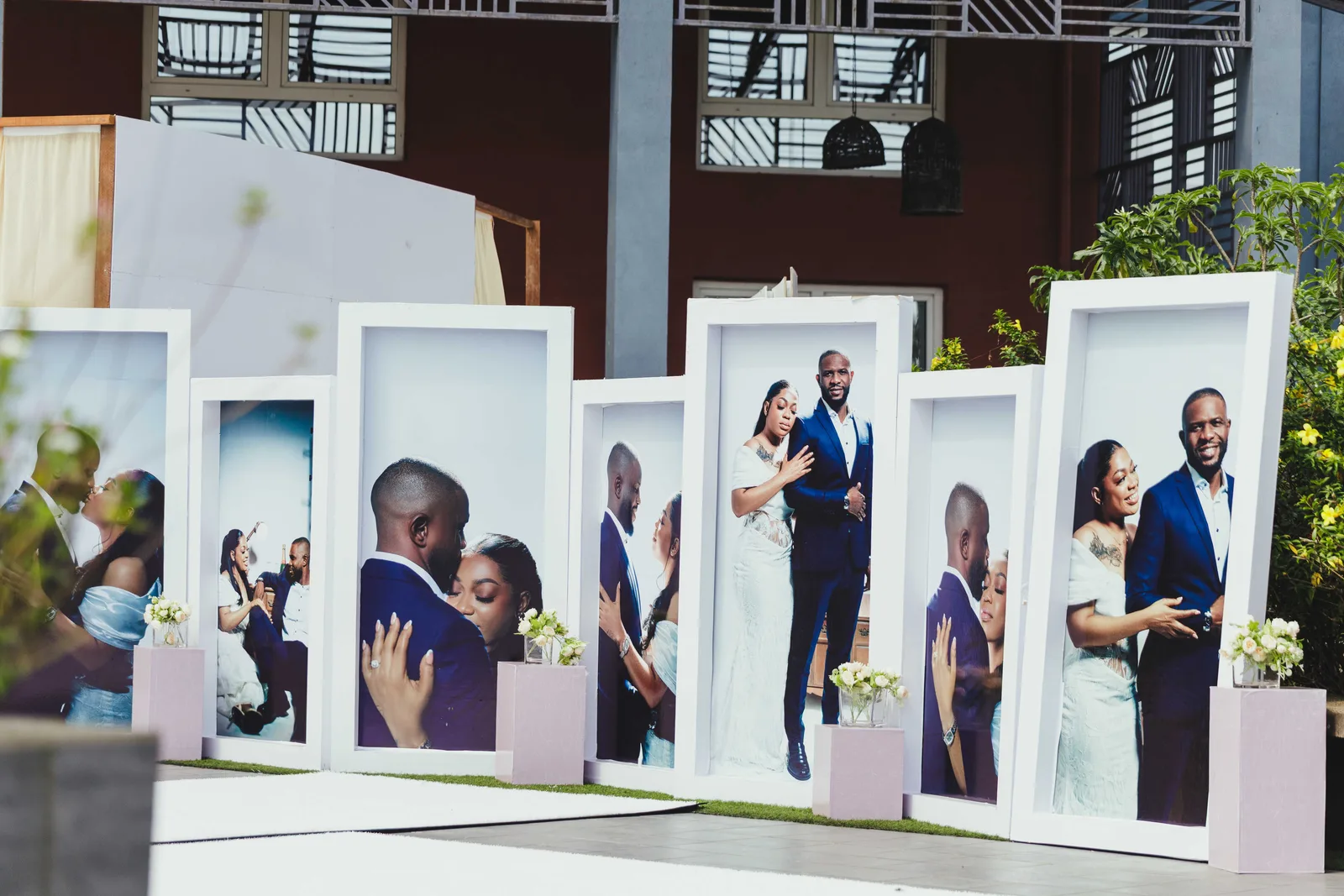 Large framed portraits of a couple standing in a row at a wedding reception