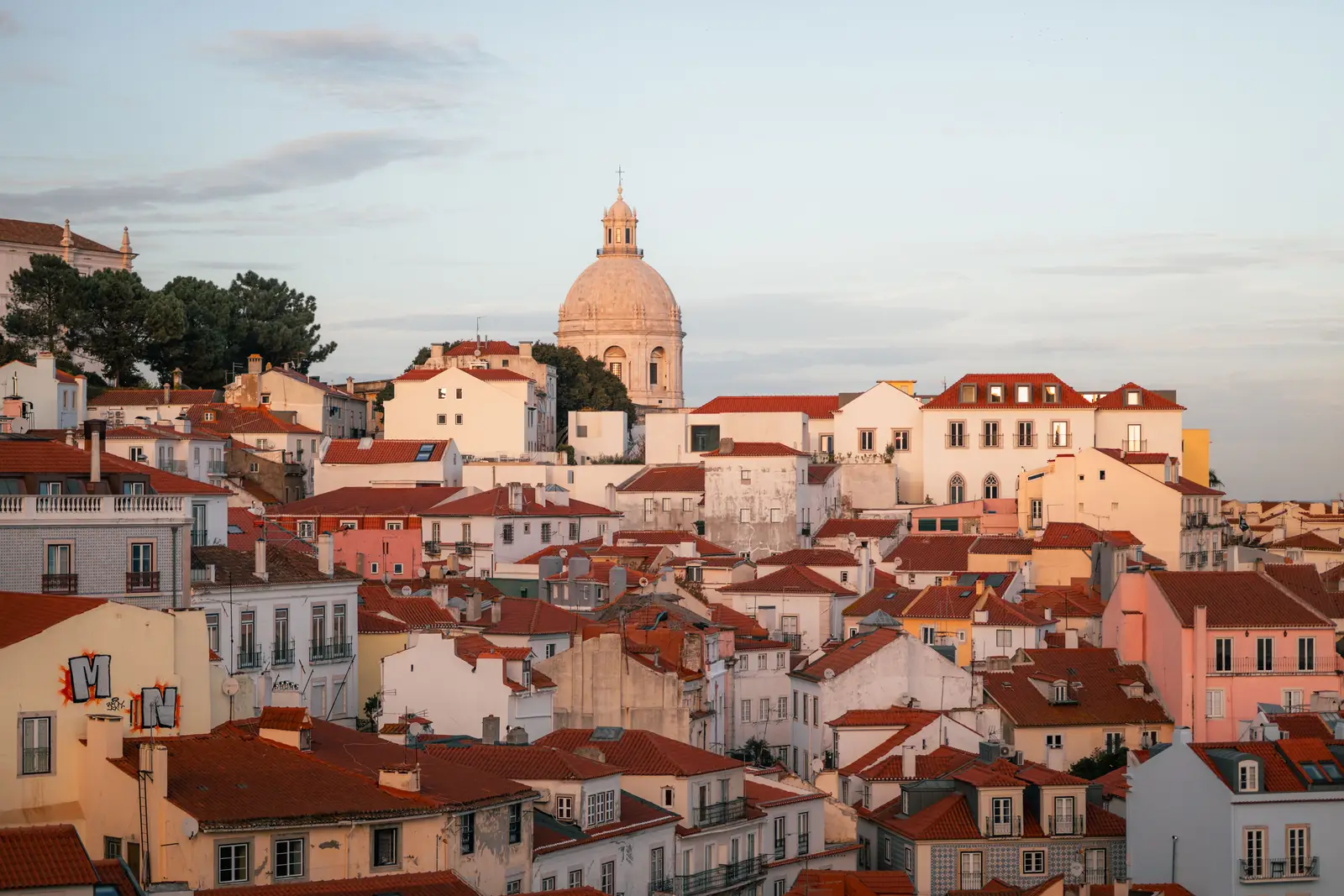 Terracotta rooftops of Alfama tumbling down towards the river