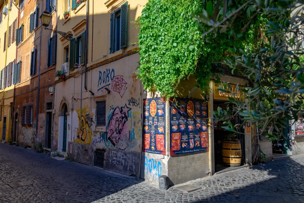 A narrow Trastevere lane with ivy and shuttered windows