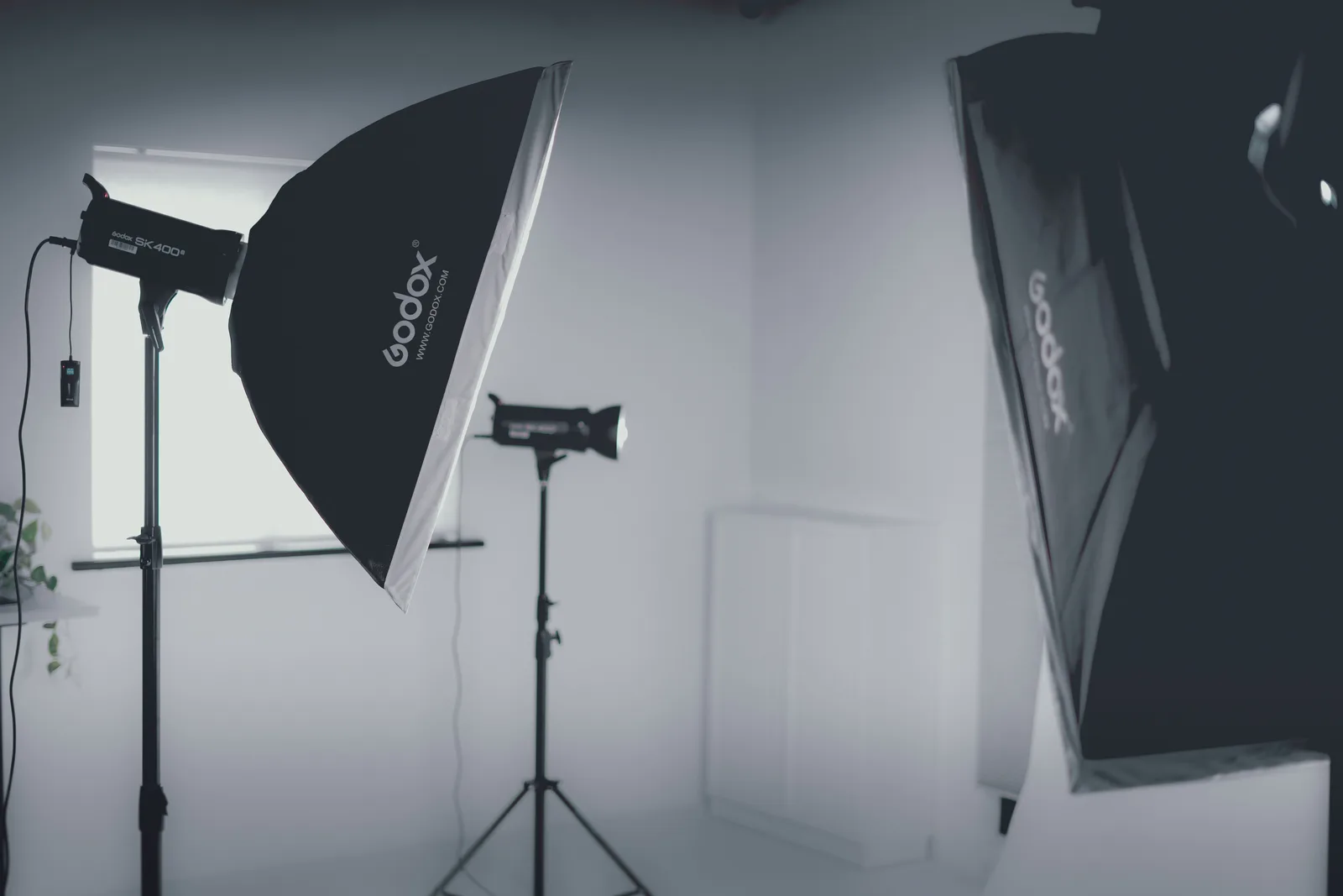 Two studio strobes with softboxes set up in a white room