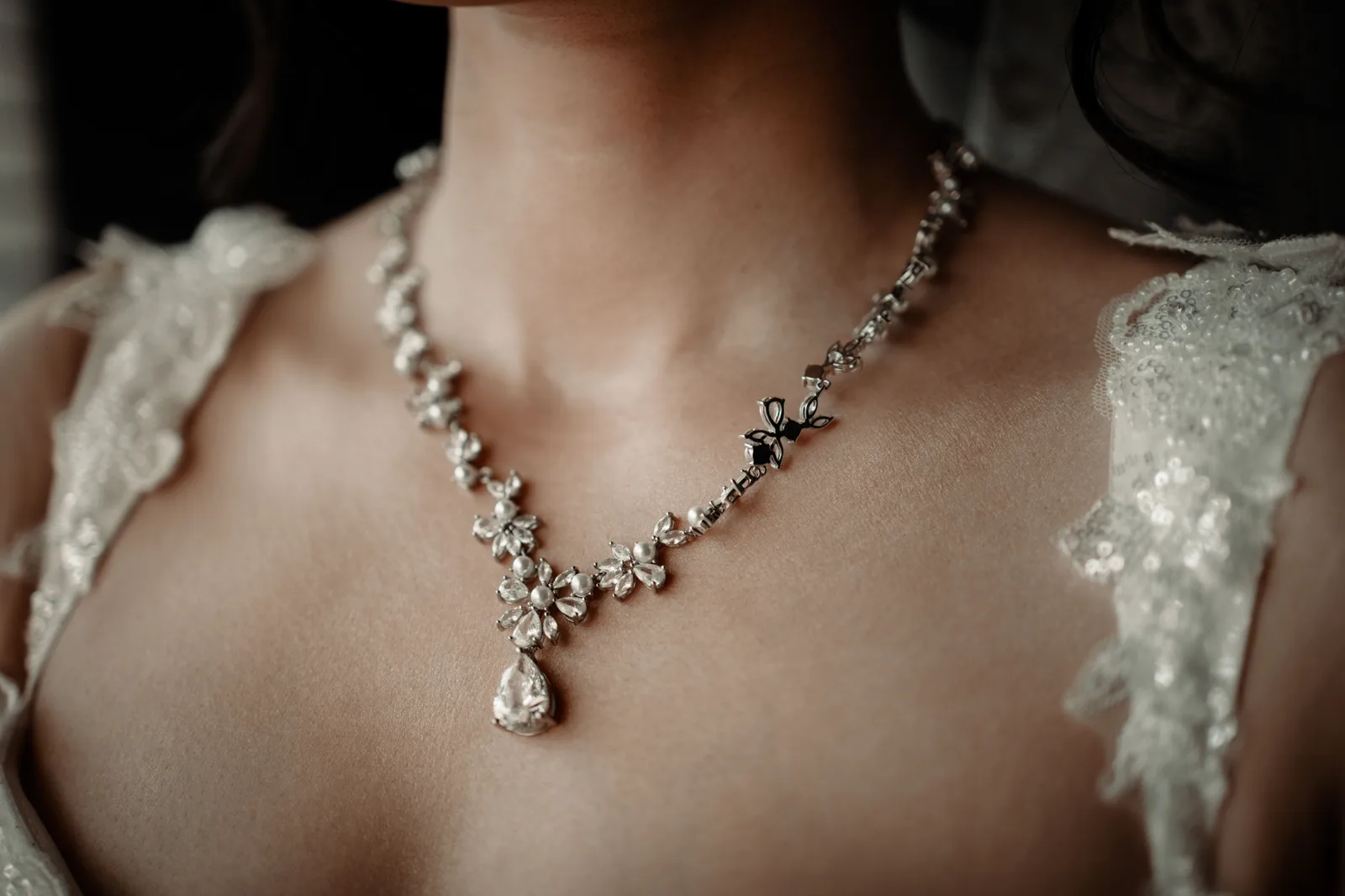 A diamond necklace worn, with the stones catching the light