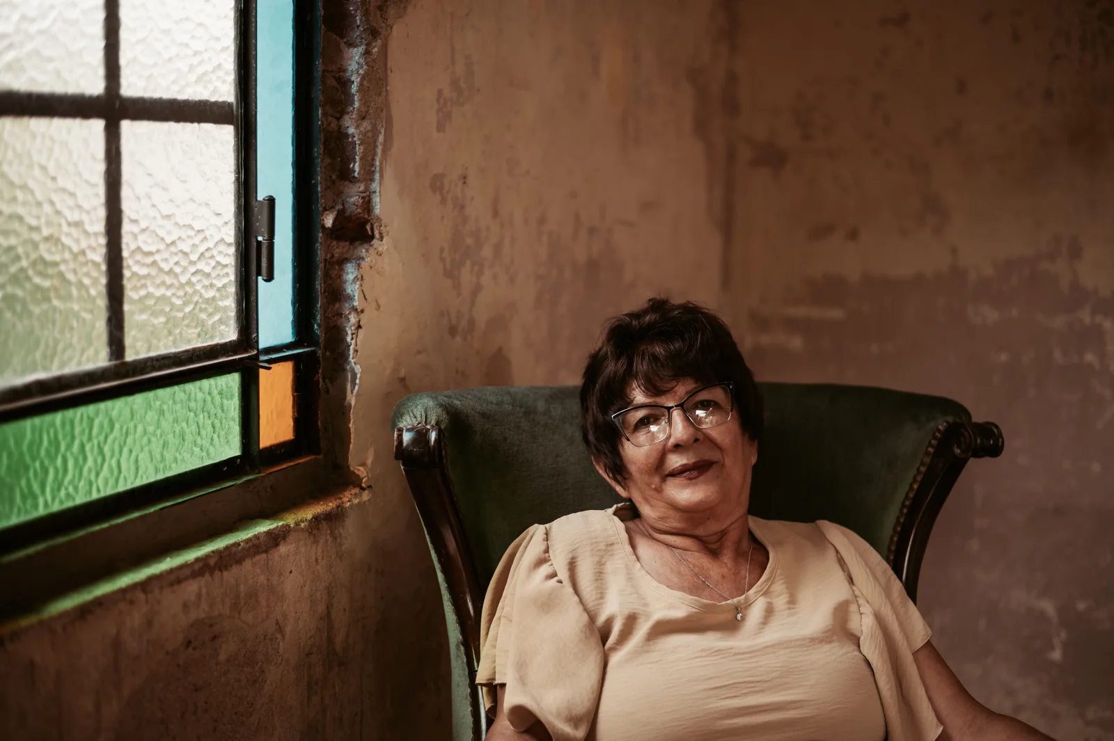 A woman in glasses photographed in soft window light