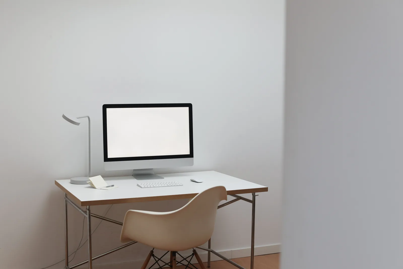 A monitor on a plain desk in an evenly lit room