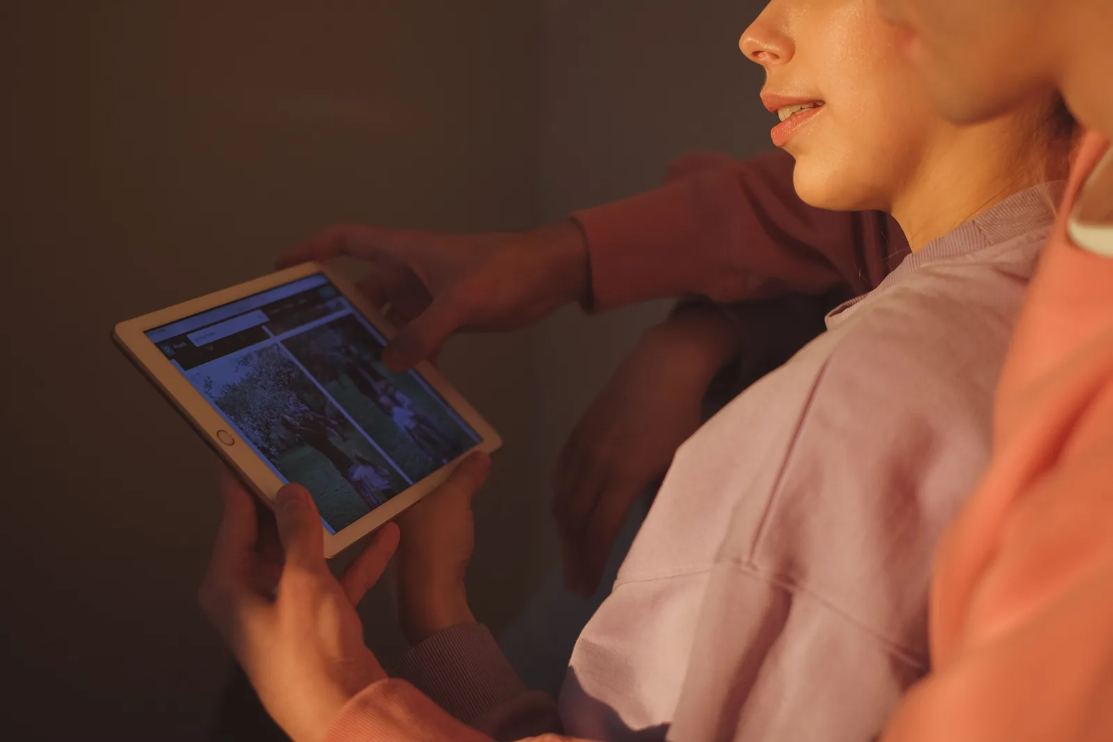 Two people looking through photos together on a tablet