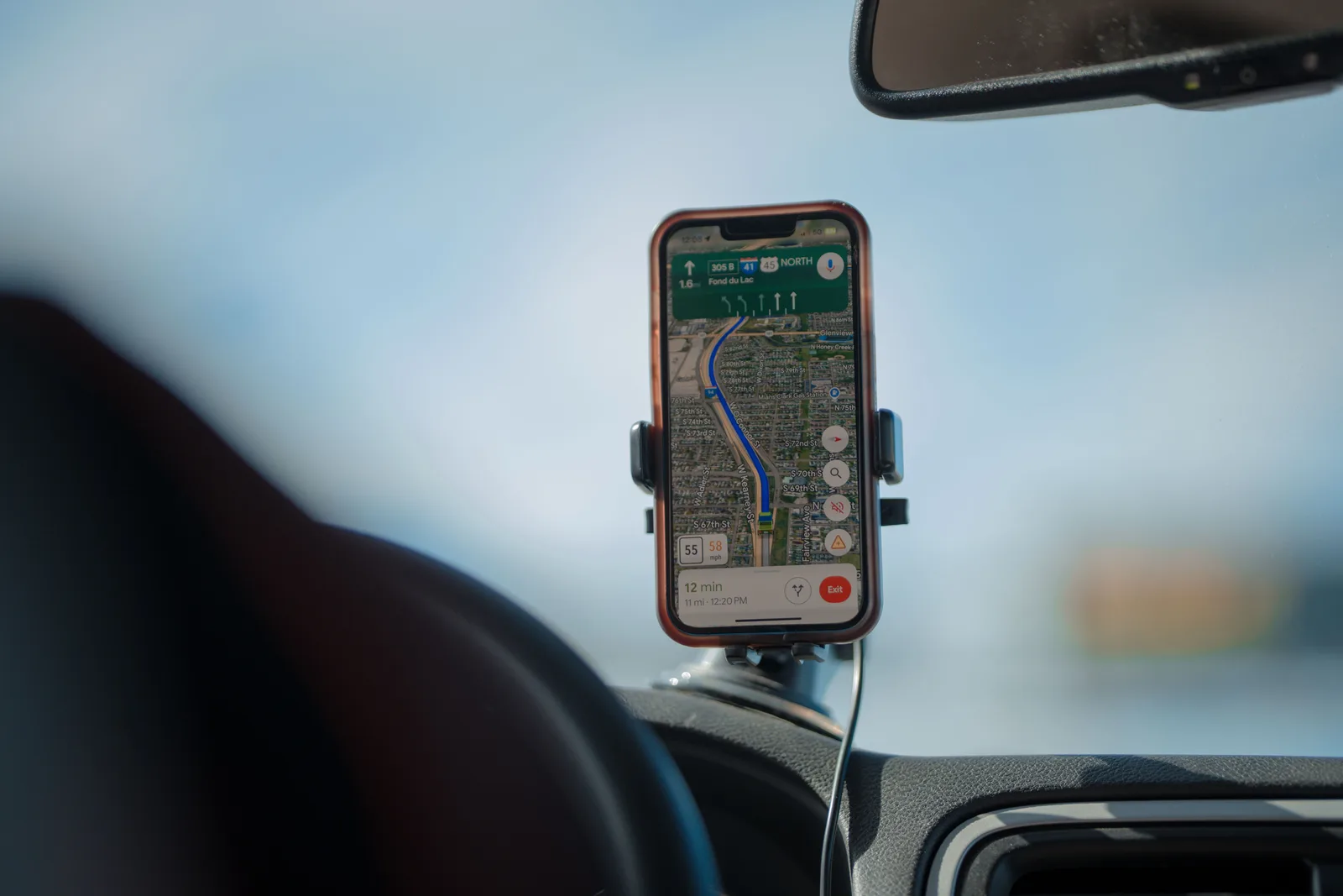 A navigation app running on a phone mounted to a car windscreen