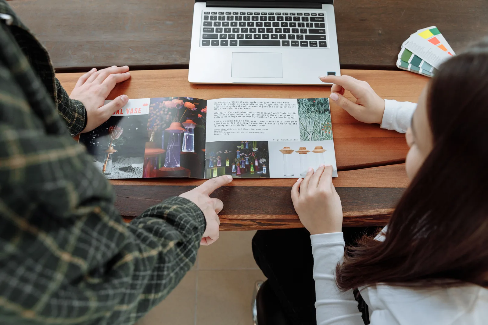 Two people going through a printed guide together at a table