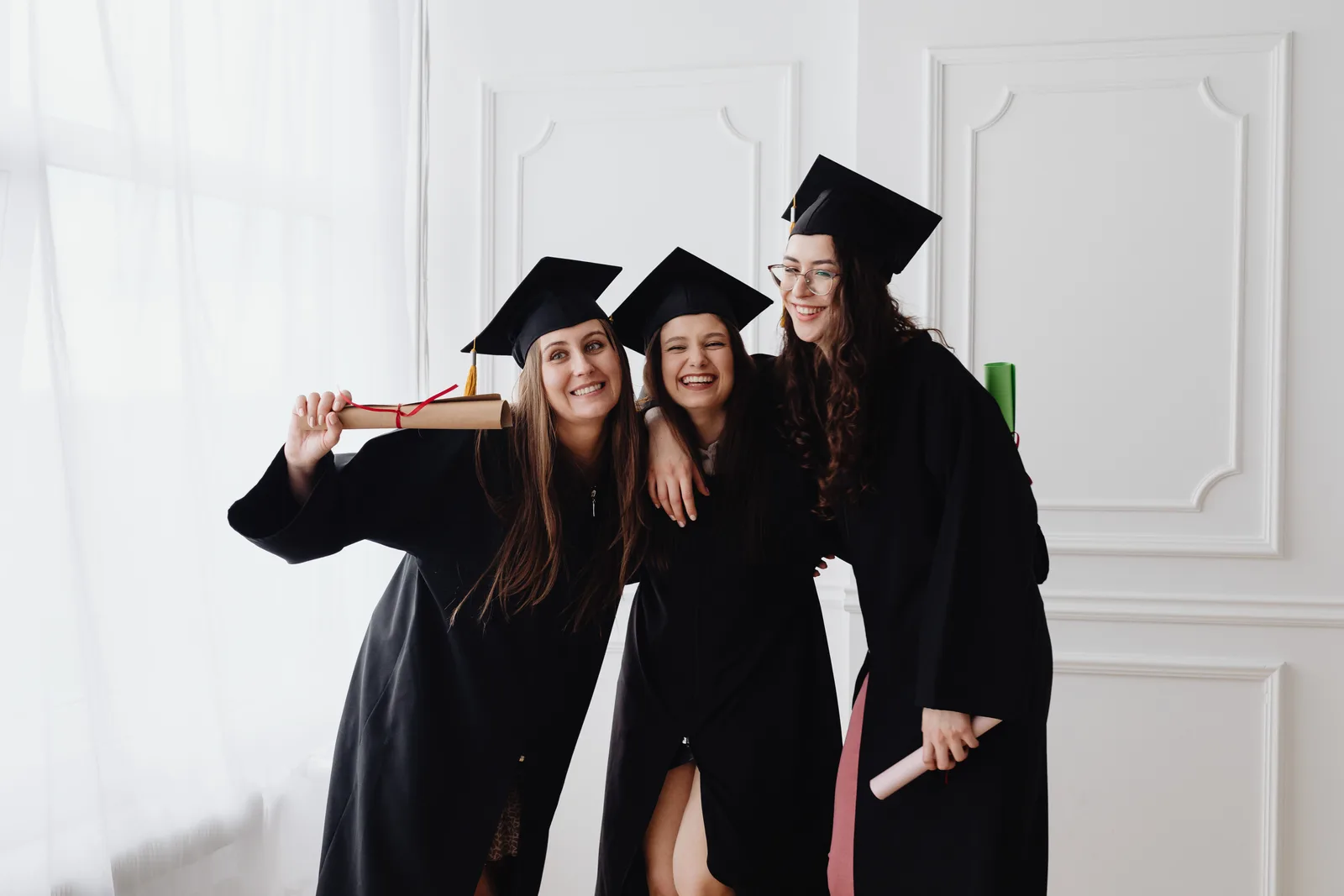 Graduates laughing together after a ceremony