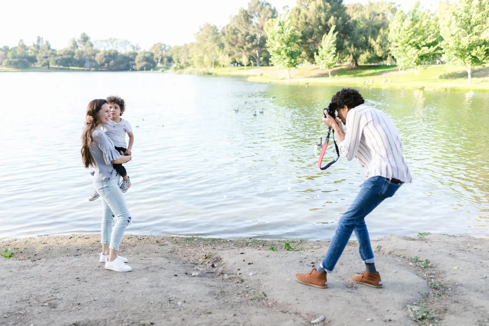 A photographer photographing a mother and child beside a lake