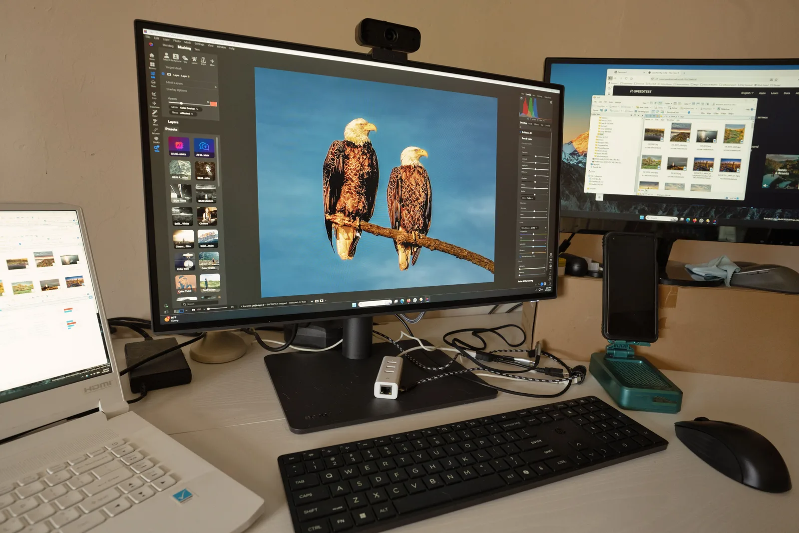 A photographer workspace with a monitor and a card reader