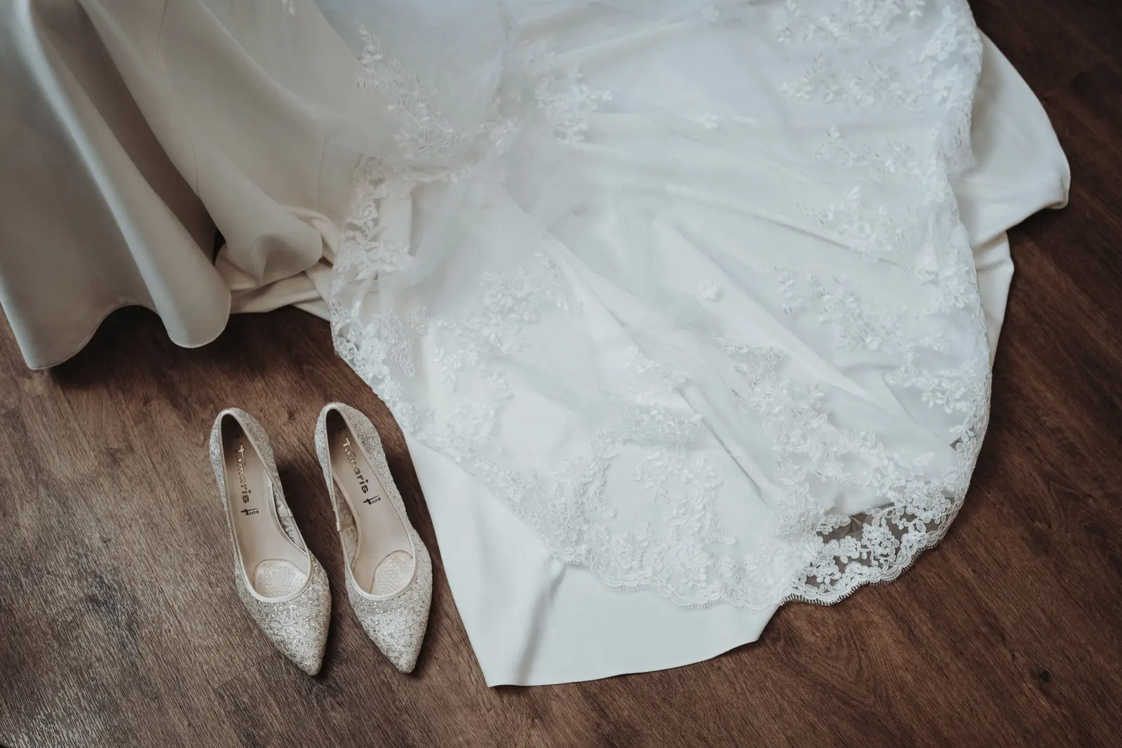 Wedding shoes and dress details laid out before the ceremony