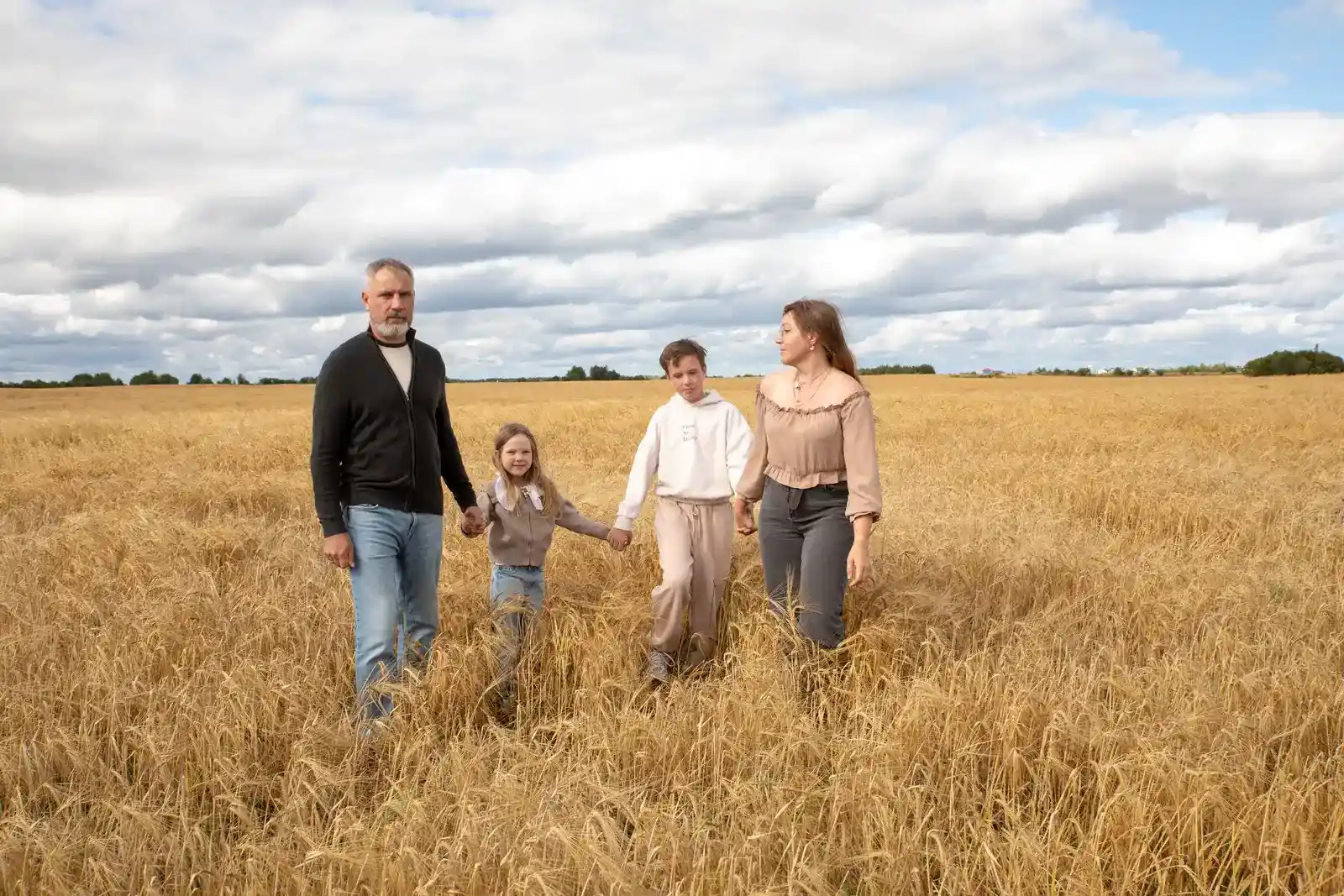A family walking together through a field in autumn