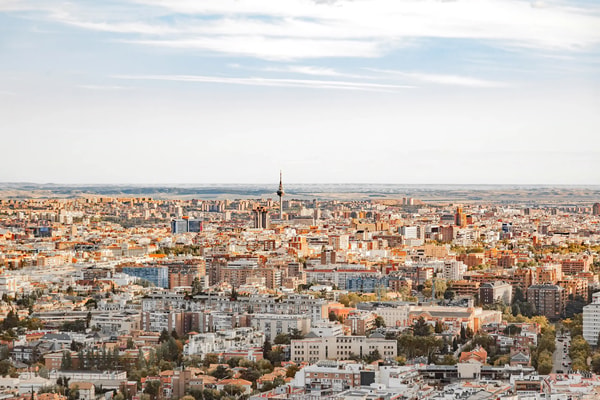 Elevated view over a dense city of terracotta rooftops at sunset