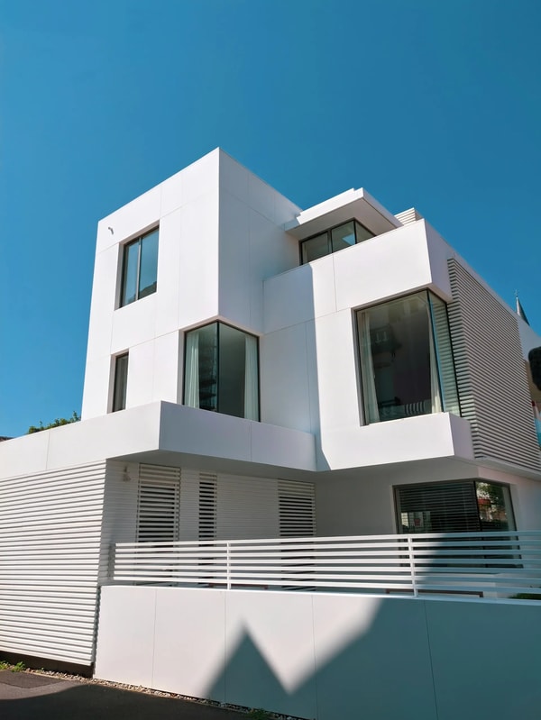 White cubic modernist house with sharp shadows under a blue sky