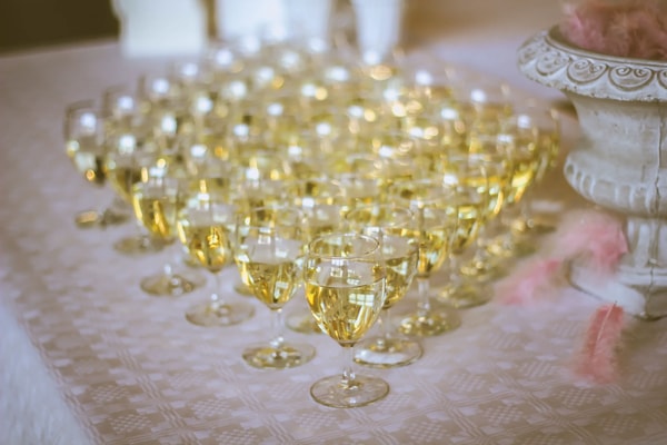 Rows of filled champagne glasses on a white tablecloth, waiting for the toast