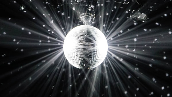 A mirror ball throwing white rays across a dark ceiling