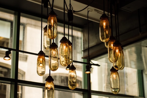 Clusters of glass pendant lamps glowing in front of tall windows