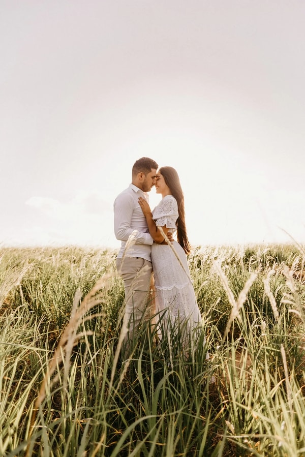 Couple forehead to forehead in a field of tall pampas grass