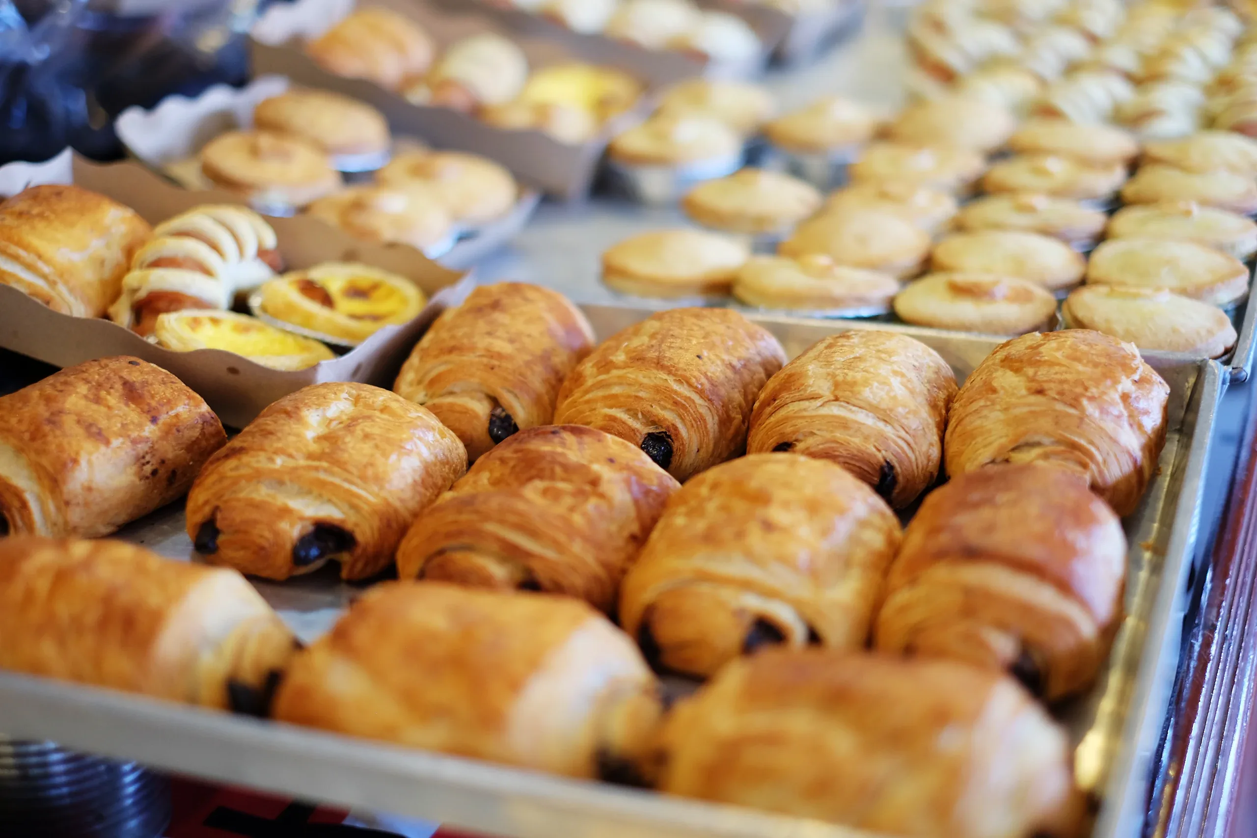 Trays of croissants, pains au chocolat and custard tarts lined up for the morning break